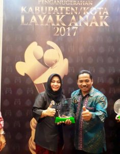 Kepala Dinas PP dan PA Kotamobagu, Siti Rafiqah Bora dan Sekertaris Dinas Kependudukan dan Catatan Sipil Kotamobagu, Mulyono Mokodompit, saat menerima penghargaan Percepatan Cakupan Akta Anak. 