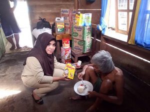 Sekertaris Dinas Sosial, Suhertien Tagela, saat menyalurkan bantuan kepada warga di desa Kopandakan I.