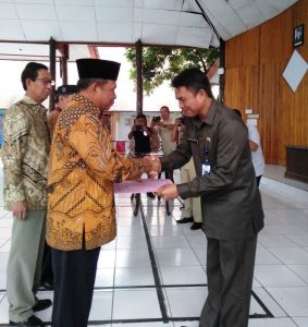 Sekertaris Daerah Kotamobagu, Tahlis Gallang, saat menyerahkan SK pelantikan kepada salah pengurus FPK Kotamobagu.