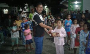 Tampak Kepala BPBD Kota Kotamobagu menyerahklan bantuan kepada salah satu anak korban kebakaran.