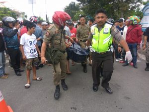 Tampak anggota dari Satuan Lantas Polres Bolmong dan Satpol PP saat mengevakuasi korban.