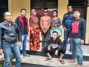 Dengan tangan diborgol tersangka pelaku jambret diapit oleh dua Polwan yang menyamar menjadi pembeli di pasar serasi.