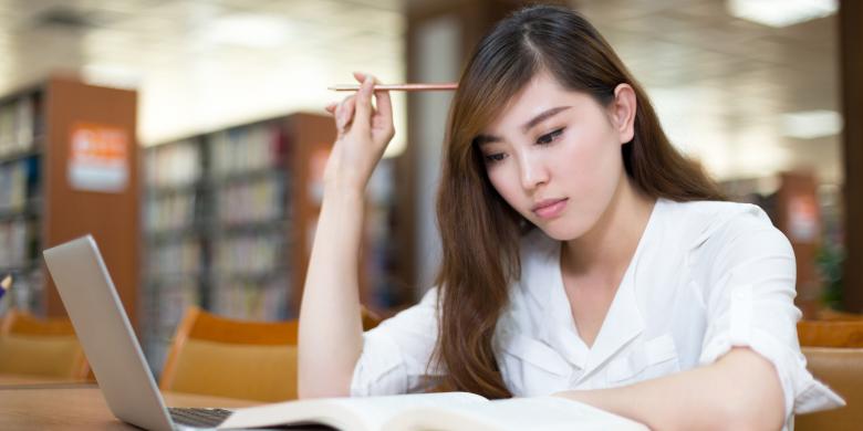 Mahasiswa mengerjakan tugas dengan Leptop