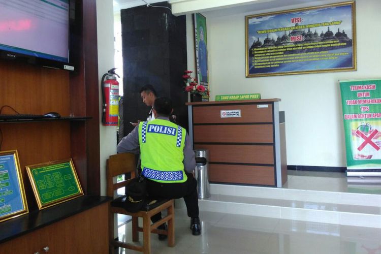 Seorang polisi menjaga area masuk ruang sidang