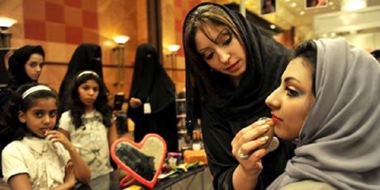 Seorang wanita Arab Saudi merias wajah seorang wanita lainnya